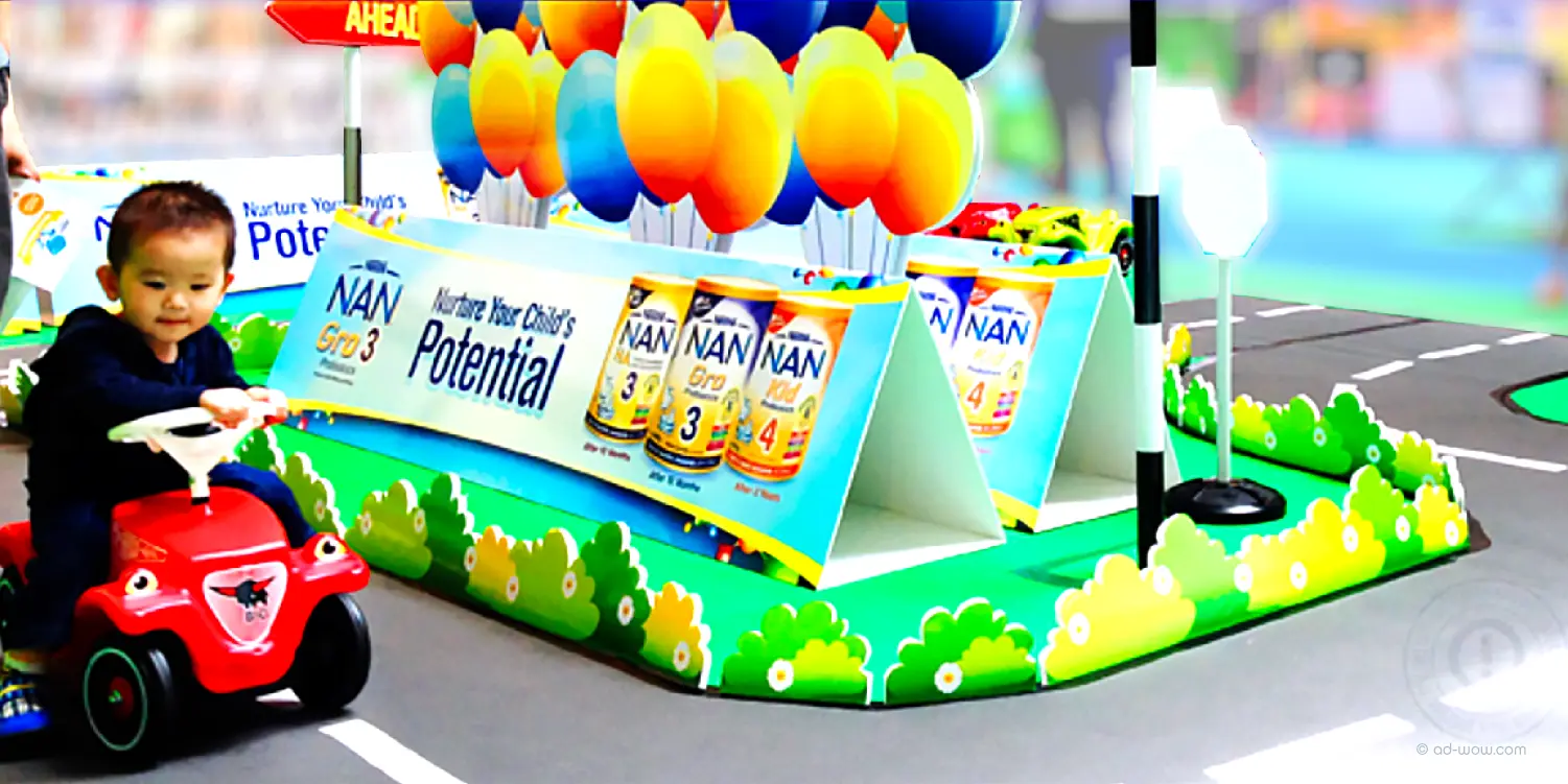 Nestlé NAN roadshow event booth design featuring kids' ride-on car activation, Singapore
